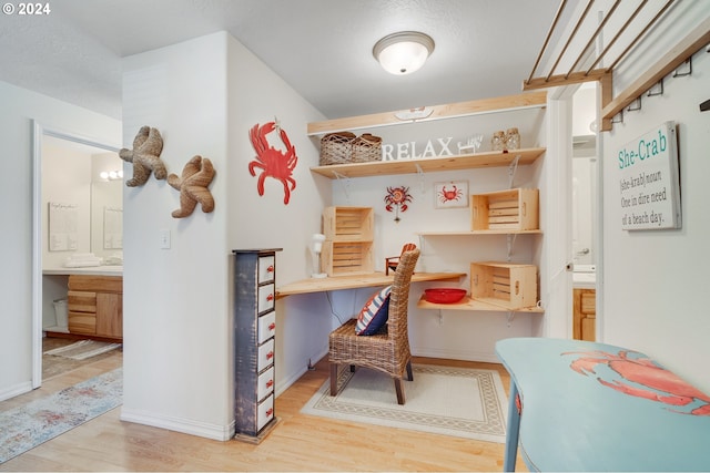 office with light wood-type flooring and a textured ceiling