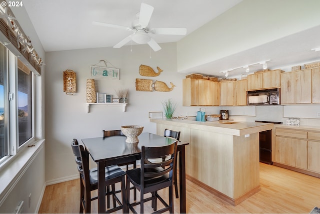 dining room featuring ceiling fan, lofted ceiling, and light hardwood / wood-style flooring