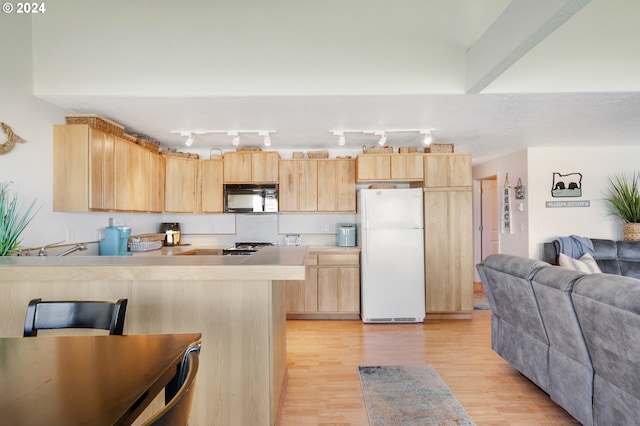 kitchen with white fridge, light brown cabinets, and light hardwood / wood-style flooring