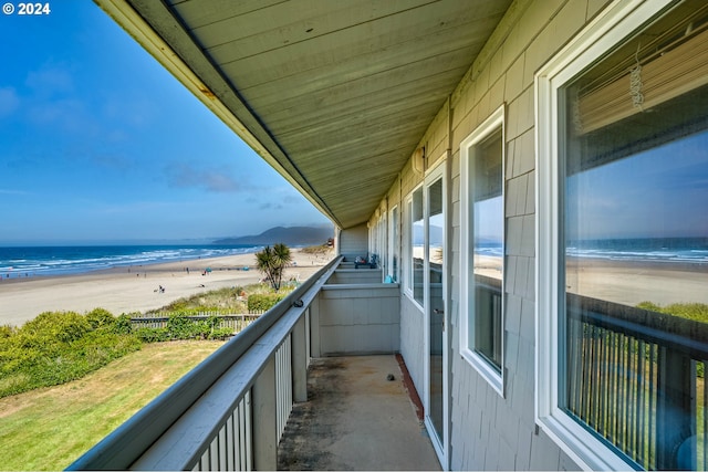 balcony featuring a water view and a view of the beach