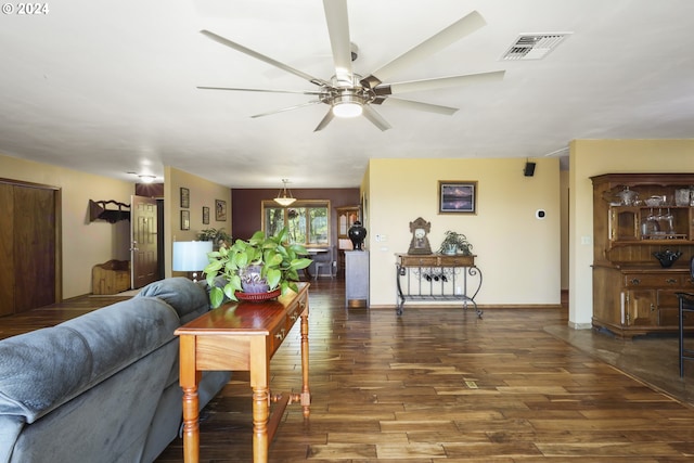 living room featuring ceiling fan and dark hardwood / wood-style floors