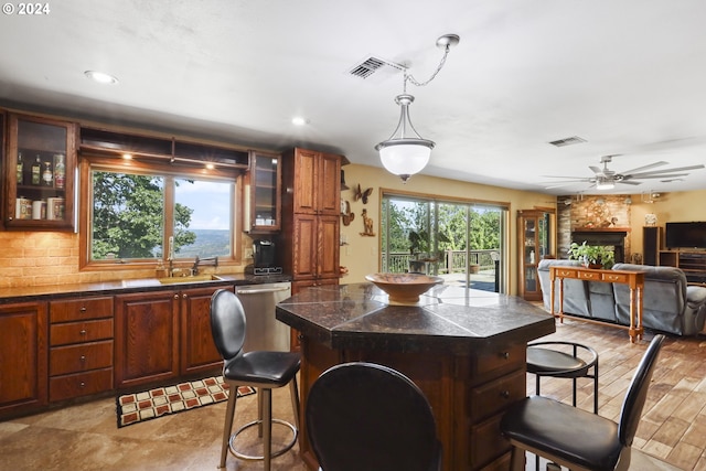 kitchen with plenty of natural light, a kitchen island, light hardwood / wood-style floors, and tasteful backsplash