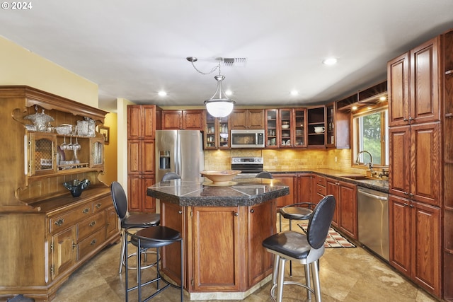 kitchen with a breakfast bar, a center island, stainless steel appliances, and decorative light fixtures