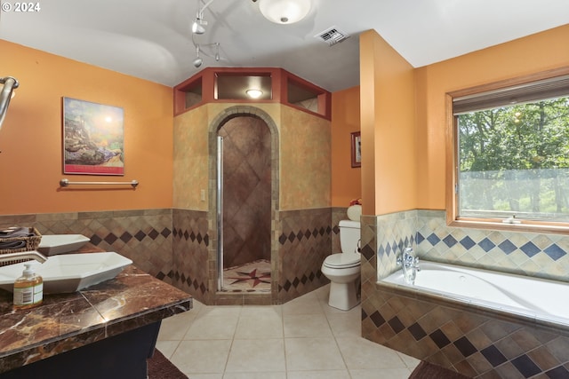 bathroom featuring tile patterned floors, separate shower and tub, and toilet