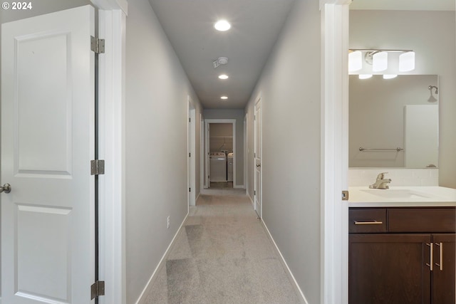 hallway featuring sink and light colored carpet