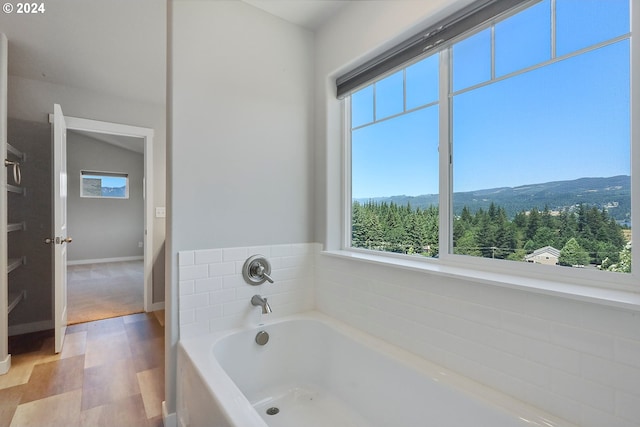 bathroom featuring a bath and a mountain view