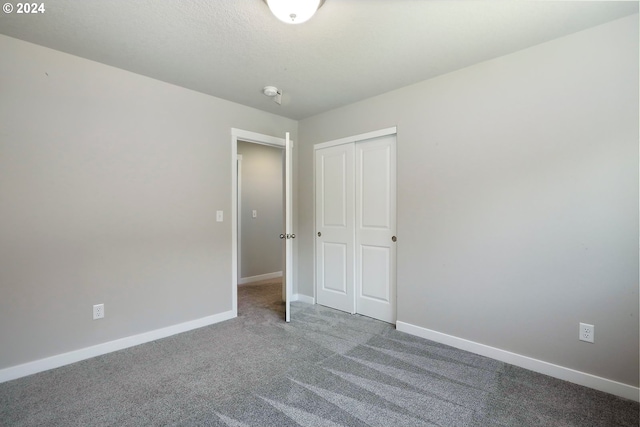 unfurnished bedroom with a closet and carpet floors