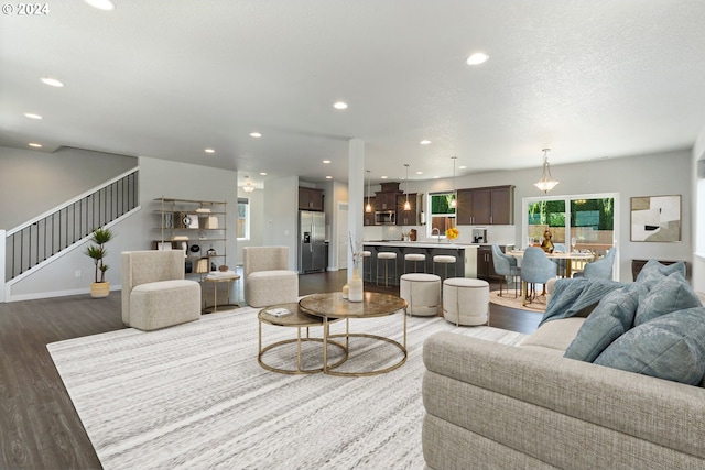 living room with dark hardwood / wood-style flooring and a textured ceiling