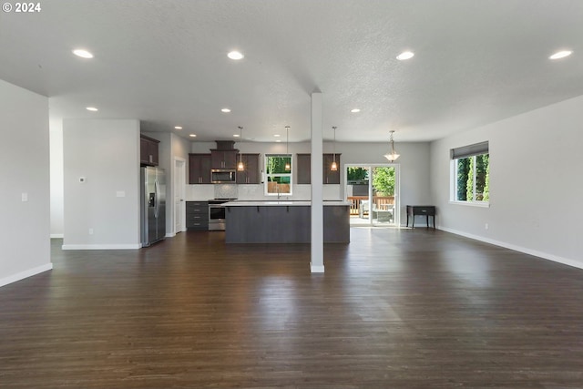 unfurnished living room with a textured ceiling and dark hardwood / wood-style floors