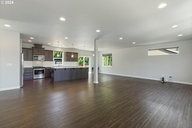 unfurnished living room with dark wood-type flooring and a textured ceiling