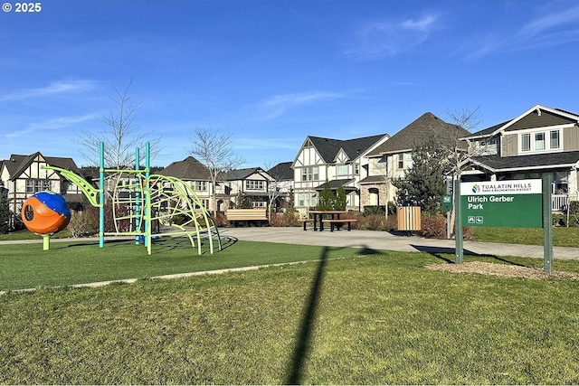 community playground featuring a residential view and a lawn