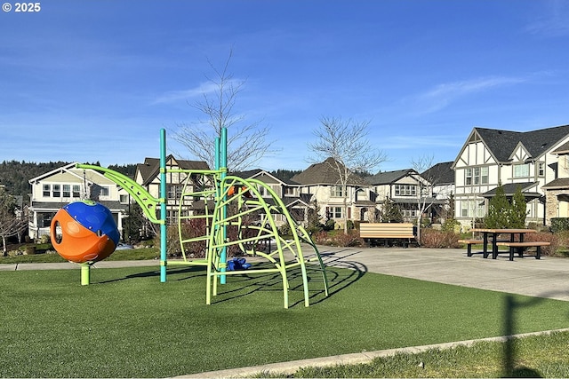 community jungle gym featuring a lawn and a residential view