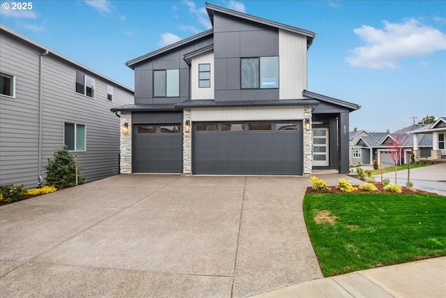 modern home with a garage, stone siding, and concrete driveway