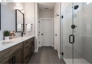 bathroom with tile patterned flooring, vanity, and a shower with shower door