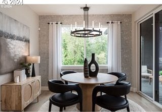 dining space with a wealth of natural light, an inviting chandelier, and light wood-style flooring