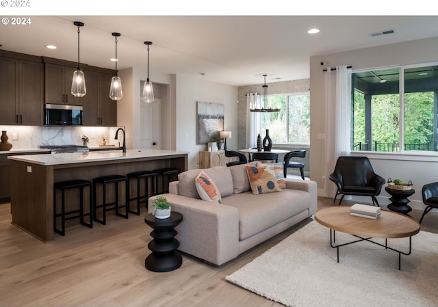 living room featuring light hardwood / wood-style floors and an inviting chandelier