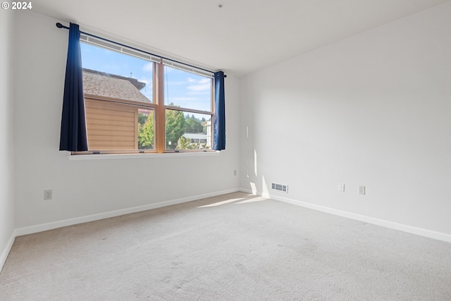 carpeted spare room featuring baseboards and visible vents