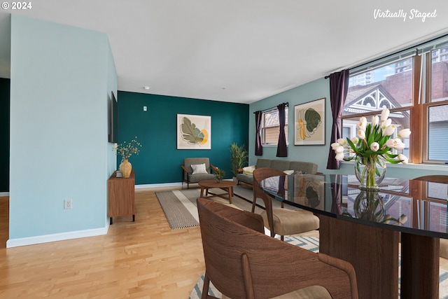 dining room featuring light wood-type flooring, plenty of natural light, and baseboards