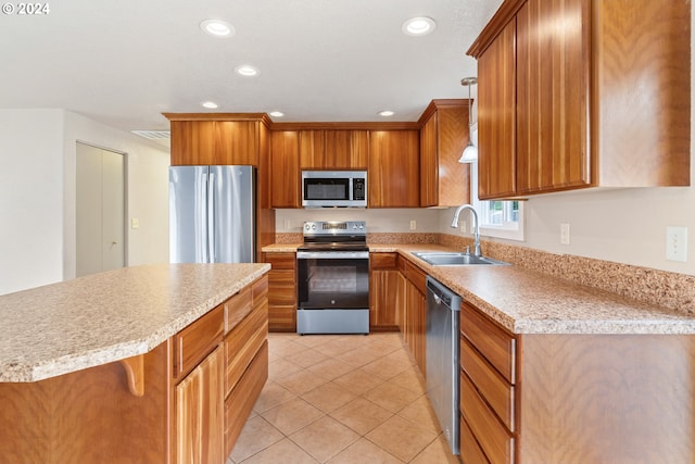 kitchen with pendant lighting, a breakfast bar, sink, light tile patterned floors, and appliances with stainless steel finishes