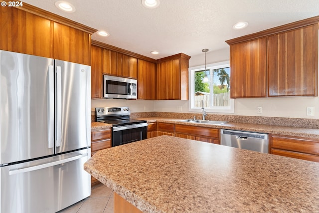 kitchen featuring sink, a textured ceiling, appliances with stainless steel finishes, decorative light fixtures, and light tile patterned flooring