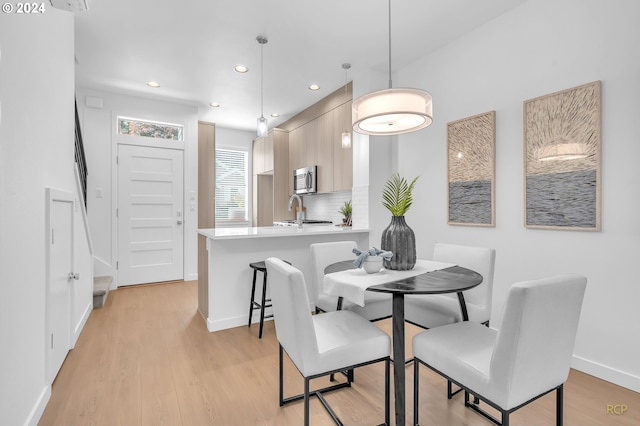 dining room with light hardwood / wood-style flooring and sink