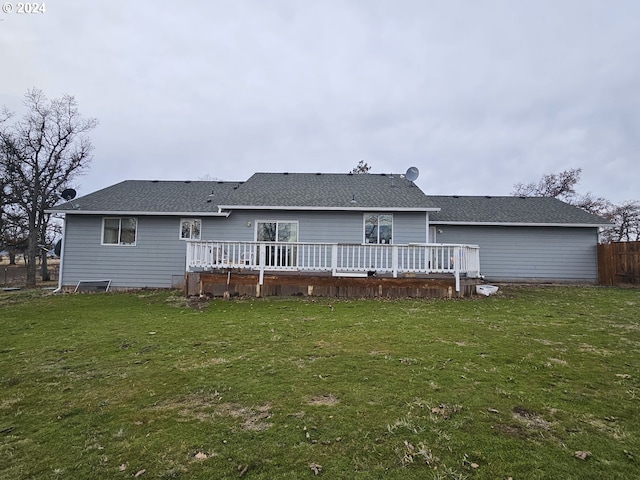 rear view of property featuring a yard and a deck