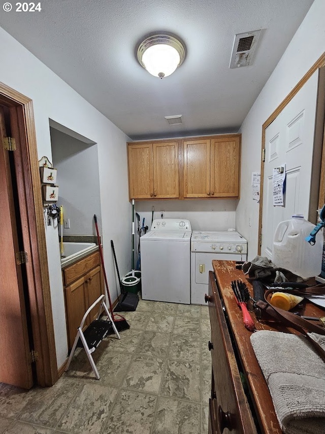 laundry room with washer and clothes dryer and cabinets