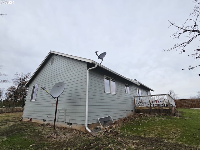 view of home's exterior featuring a lawn and a deck