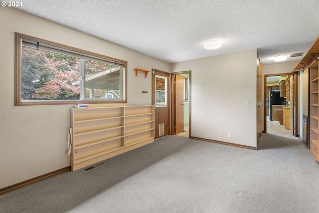 bedroom with a textured ceiling and light colored carpet