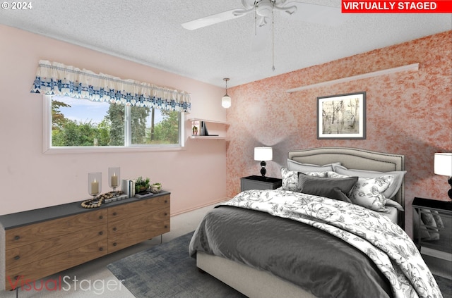 bedroom with a textured ceiling, carpet flooring, and ceiling fan