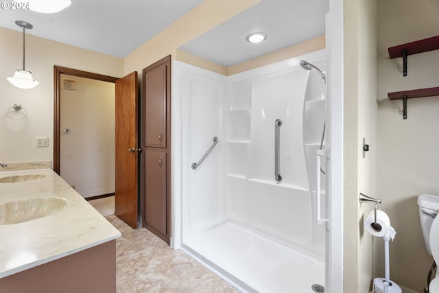 bathroom featuring toilet, walk in shower, and vanity