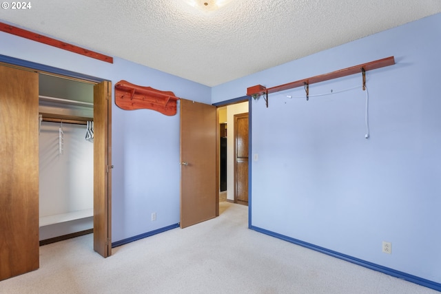 unfurnished bedroom with light carpet, a closet, and a textured ceiling