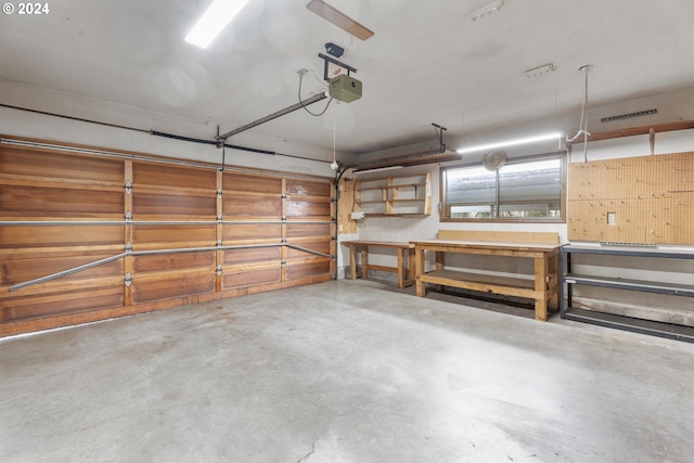 garage featuring a garage door opener and a workshop area