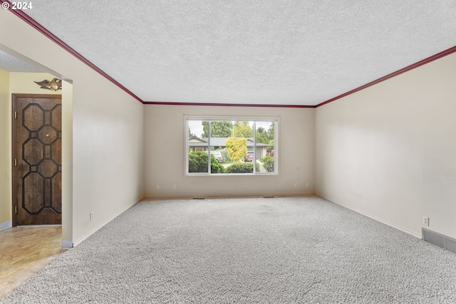 carpeted empty room with crown molding and a textured ceiling