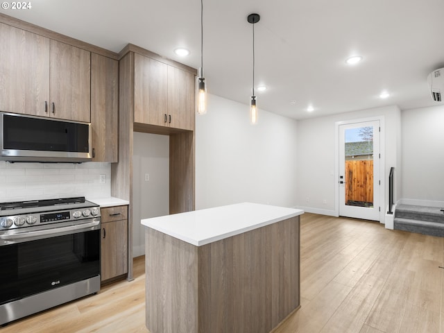 kitchen with stainless steel appliances, tasteful backsplash, hanging light fixtures, a center island, and light wood-type flooring