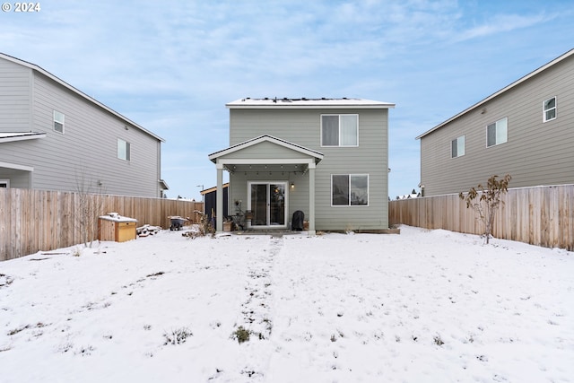 view of snow covered back of property