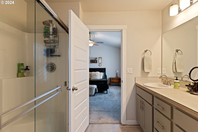 bathroom featuring an enclosed shower, vanity, vaulted ceiling, and ceiling fan