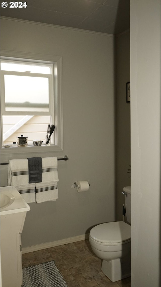 bathroom featuring vanity, toilet, and ornamental molding