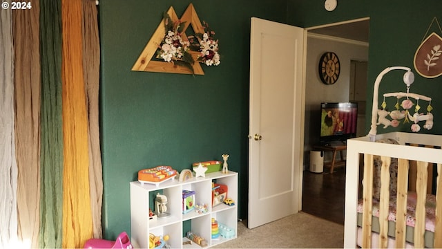 carpeted bedroom featuring a crib