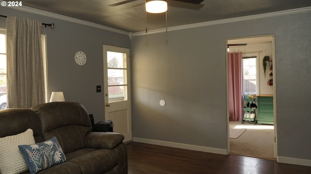 living room featuring dark hardwood / wood-style flooring, ornamental molding, and ceiling fan