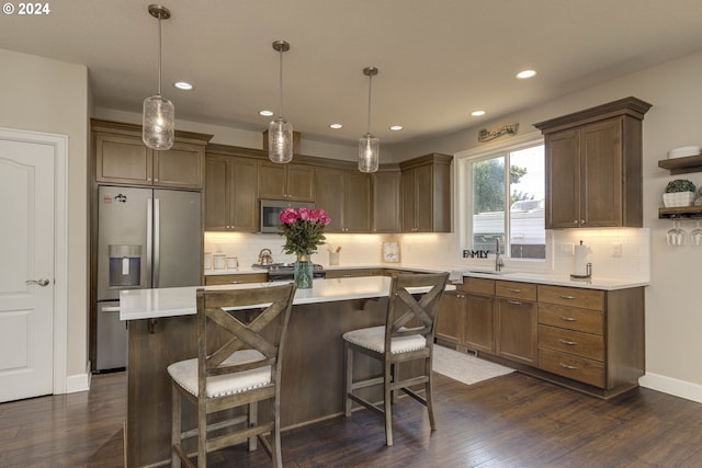 kitchen featuring stainless steel appliances, dark wood-type flooring, pendant lighting, and a kitchen island