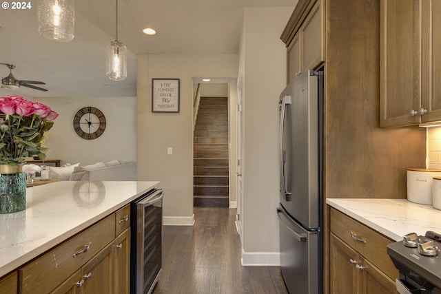 kitchen featuring light stone countertops, dark hardwood / wood-style flooring, stainless steel fridge, decorative light fixtures, and beverage cooler