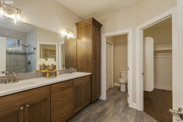 bathroom with toilet, walk in shower, hardwood / wood-style flooring, and vanity