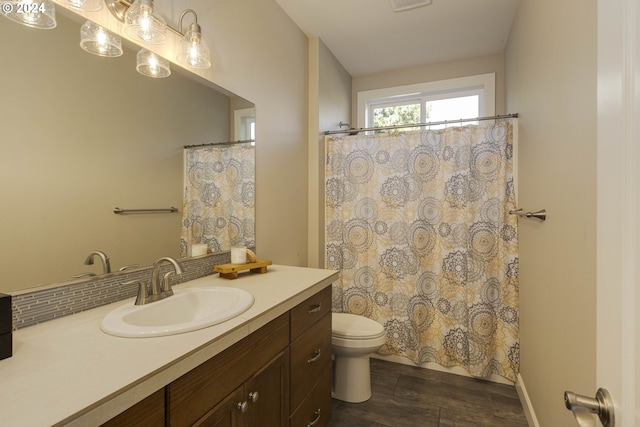 bathroom with wood-type flooring, toilet, a shower with curtain, vanity, and decorative backsplash