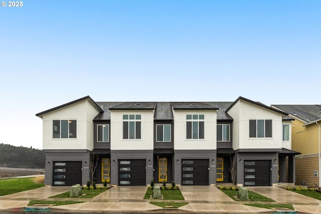 view of front of house featuring driveway, stucco siding, and a garage