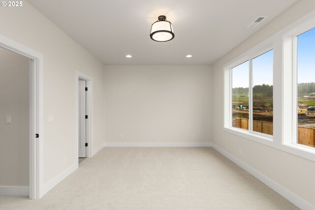 empty room with recessed lighting, light colored carpet, and baseboards