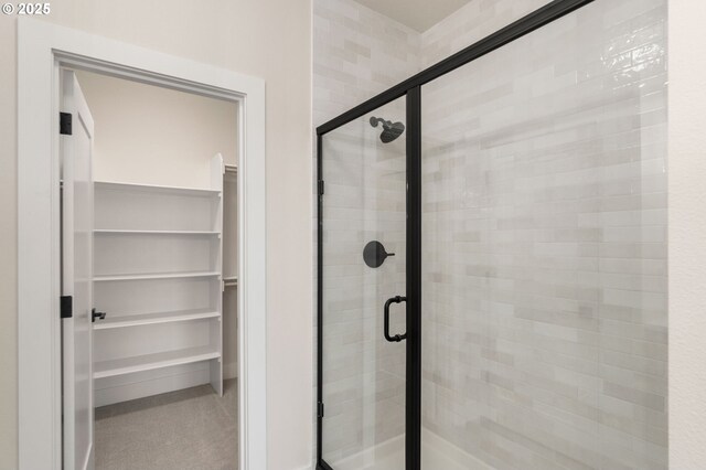 full bathroom featuring a walk in closet and a shower stall
