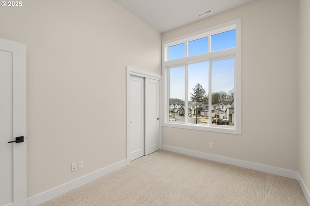 unfurnished bedroom with baseboards, visible vents, and carpet