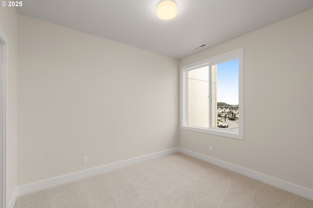 unfurnished room featuring baseboards, visible vents, and light colored carpet