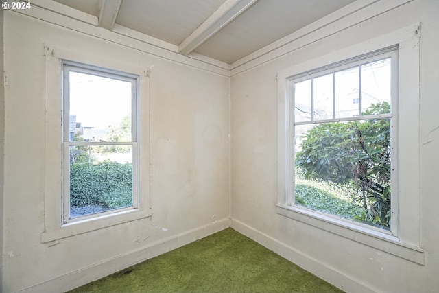 empty room with dark carpet and beam ceiling